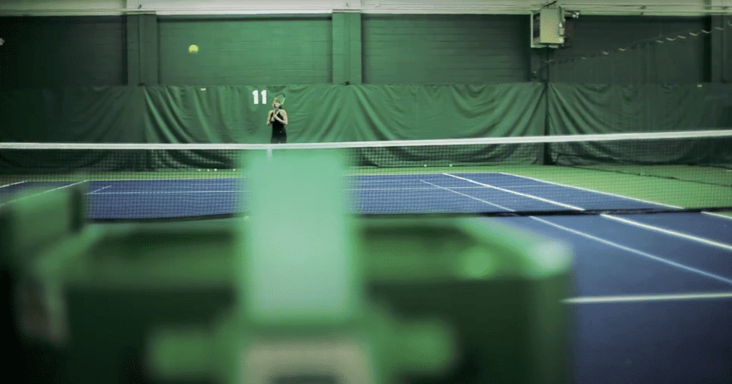 woman using the tennis ball machine to practice