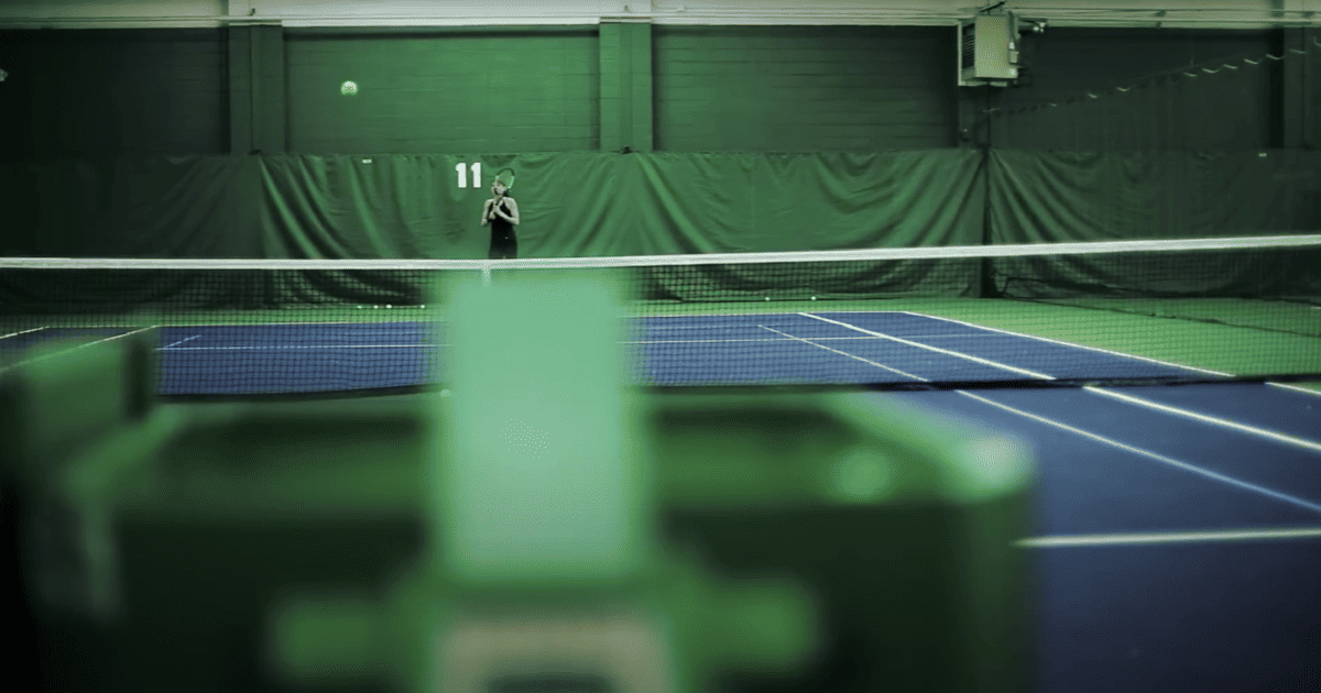 woman using the tennis ball machine to practice