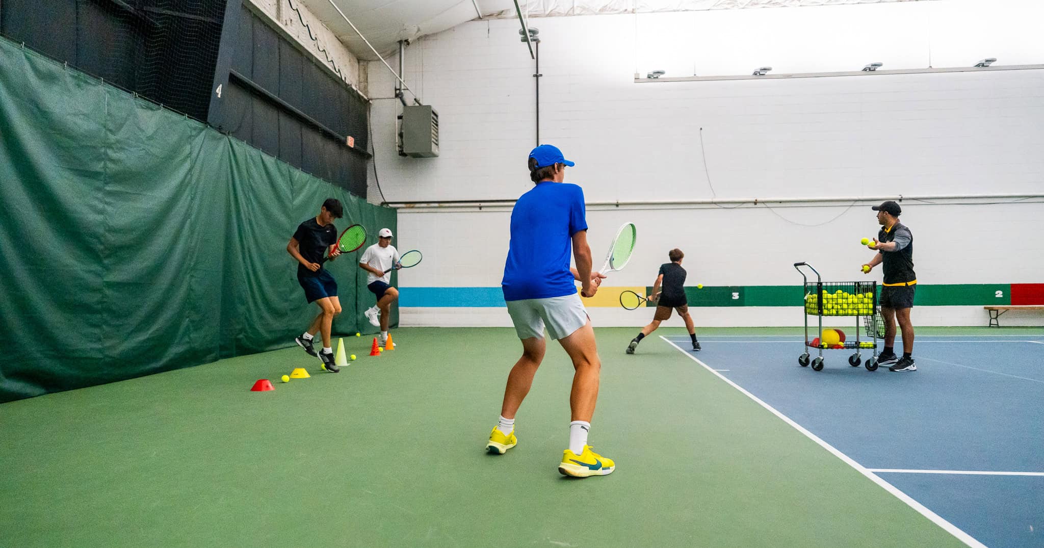 Junior tennis players undergoing a drill - Train to Win With High Performance Tennis